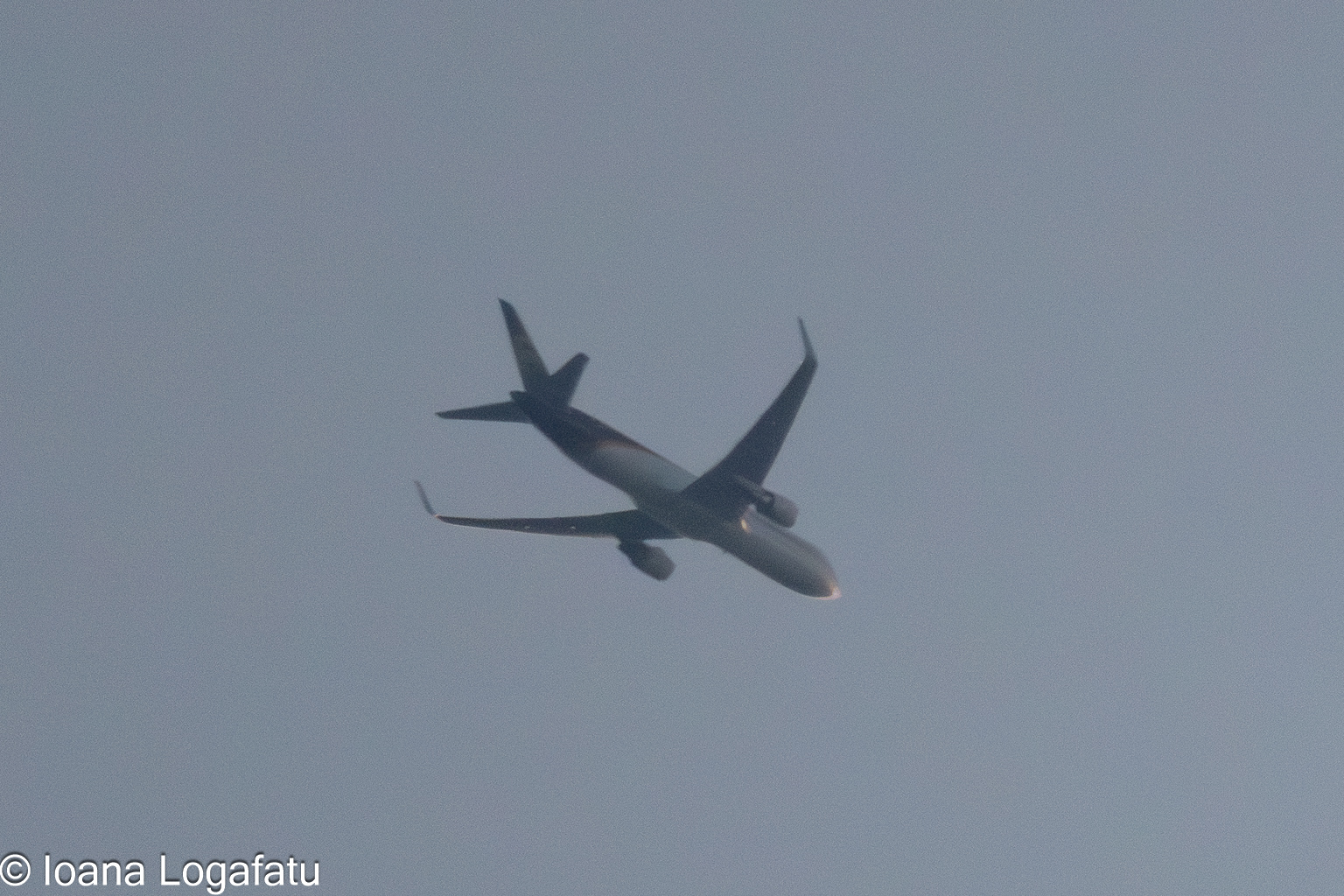 Aircraft gliding through clear blue skies above